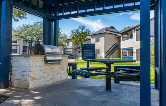 the pavilion at the community center with a grill and picnic tables