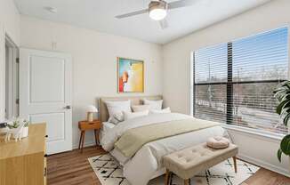 A bedroom with a large bed and a painting on the wall.