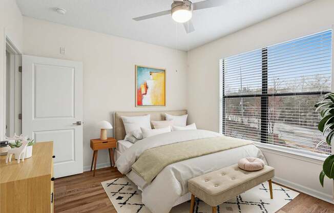 A bedroom with a large bed and a painting on the wall.