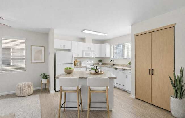 A kitchen with a table and chairs in front of it.