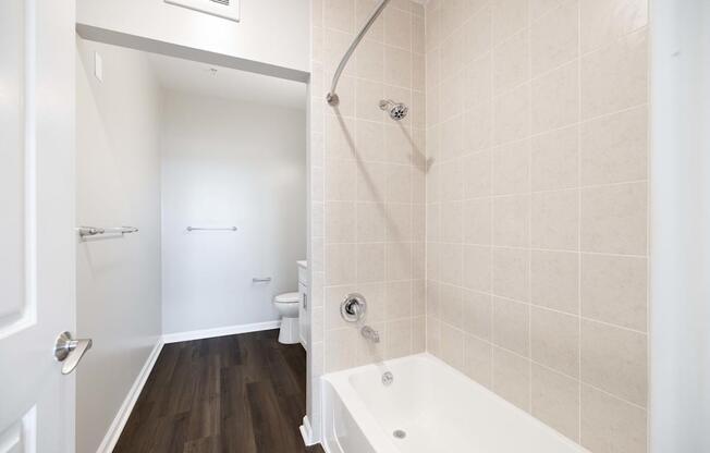 A white bathroom with a tub and toilet.