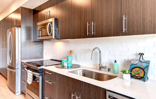 Apartments in Downtown Seattle for Rent - Metroline Flats - Modern Kitchen with Wood-Style Cabinets, Stainless Steel Appliances, and White Quartz Countertops