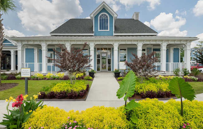 A blue and white house with a garden in front.