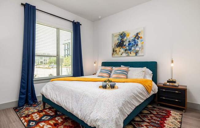 Rhythm bedroom with a large bed and a painting on the wall.