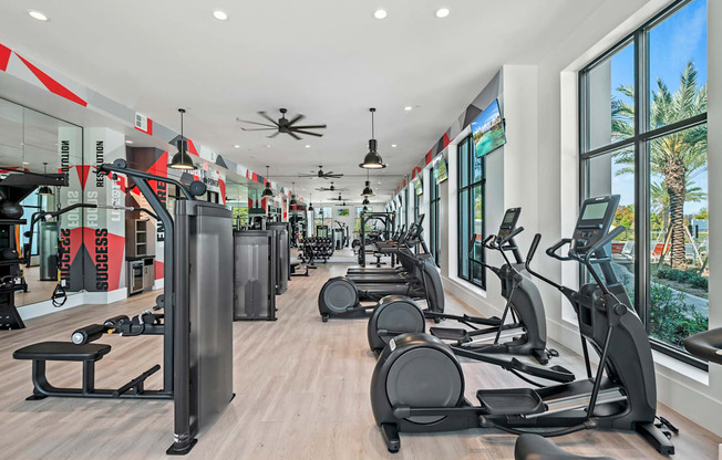 a gym with cardio equipment and windows in a building at Altis Grand Suncoast, Land O' Lakes Florida