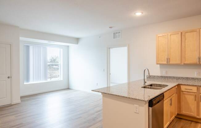 an empty kitchen and living room with a large window