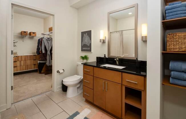A bathroom with a toilet, sink, and mirror.