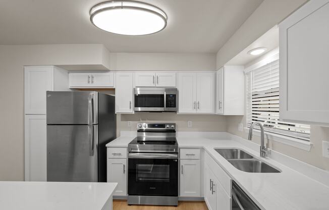 a kitchen with white cabinets and stainless steel appliances