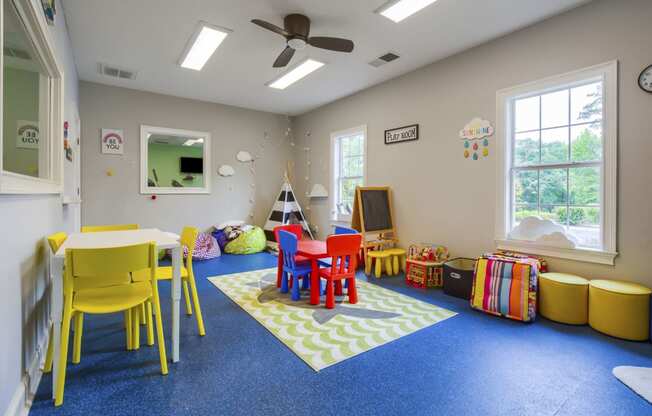 a childs play area with a table and chairs and a television