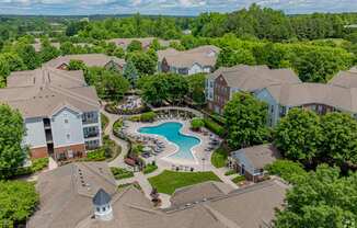 A bird's eye view of a residential area with houses and a swimming pool.