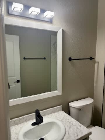 A white sink in a bathroom with a mirror above it.