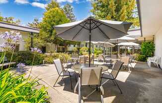 A patio with a table and chairs under an umbrella.