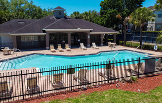 Swimming pool with lounge seating and clubhouse in the background