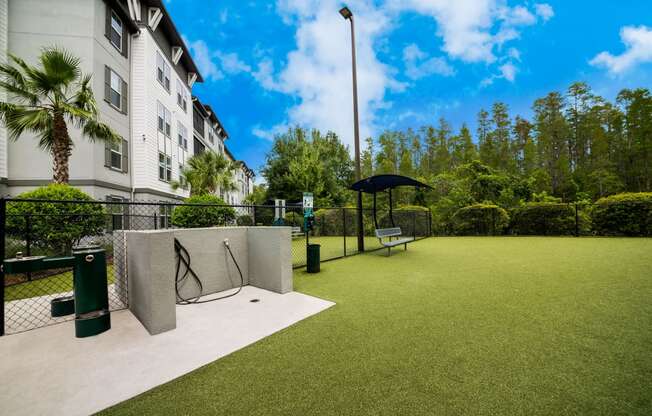 a tennis court in front of a building with an umbrella