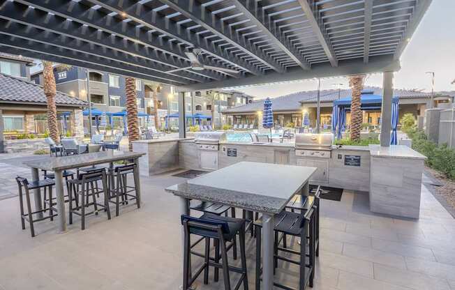 Large poolside pergola with two gas BBQ grills and high-top seating.
