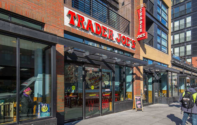 A Trader Joe's storefront with a person walking by.