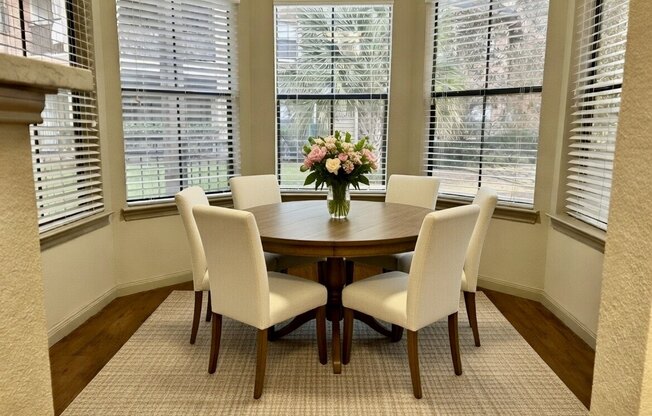 A dining room with a round table and chairs.