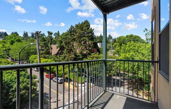 a balcony with a view of a parking lot and trees