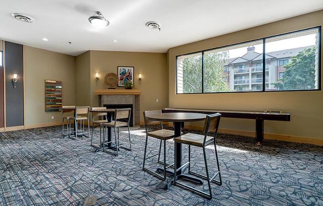 Community room with small tables and chairs and a window