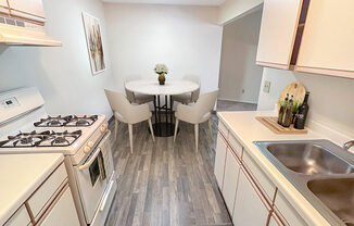 A kitchen with a table and chairs in the middle.