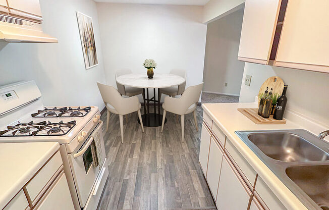 A kitchen with a table and chairs in the middle.