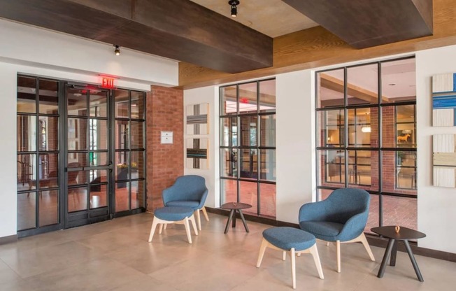 a lobby with blue chairs and glass doors