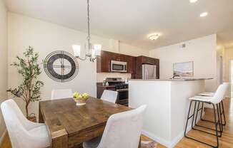 Kitchen and dining room view with dining table and chairs, and bar stools.