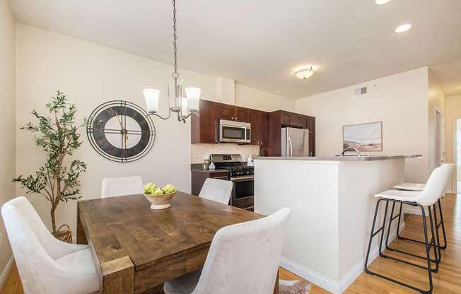 Kitchen and dining room view with dining table and chairs, and bar stools.