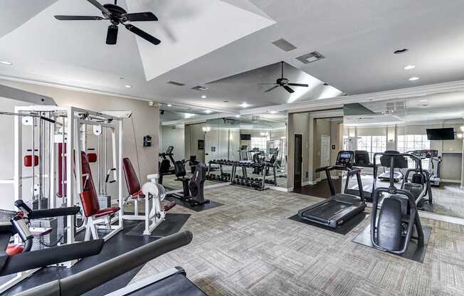 A spacious gym with a variety of equipment including treadmills, weights, and exercise machines.