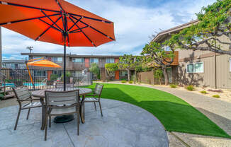 a patio with a table and chairs and an umbrella at Element LLC, Sunnyvale