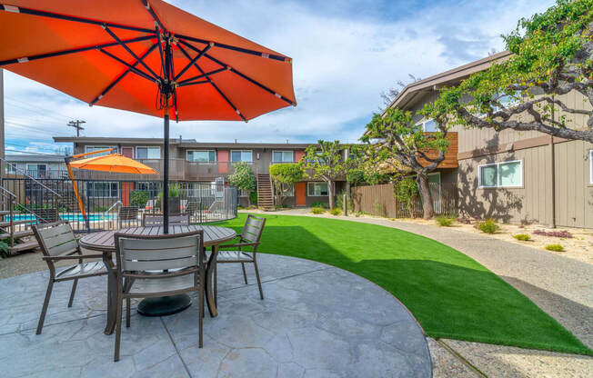 a patio with a table and chairs and an umbrella at Element LLC, Sunnyvale