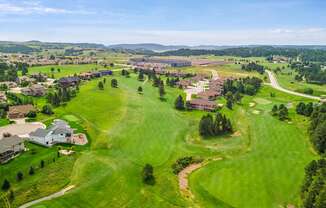 arial view of a golf course with houses in the background