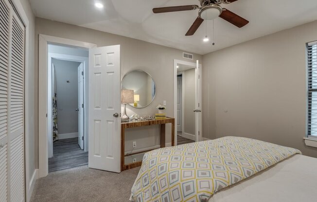 a bedroom with a bed and a ceiling fan