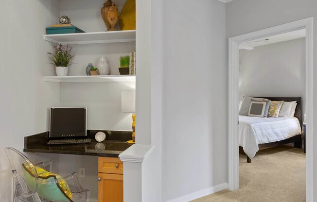 a bedroom with a desk with a laptop on it