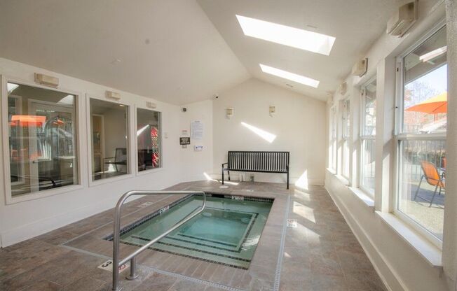 a small pool in the middle of a room with a bench