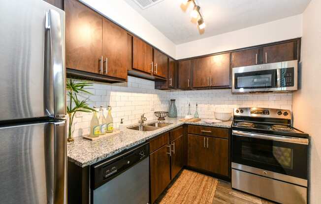 Kitchen with stainless steel appliances and granite countertops at Elme Sandy Springs Apartments, Atlanta, GA