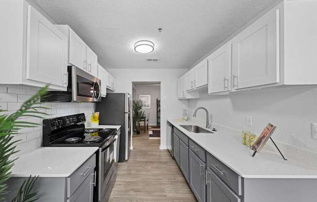 A kitchen with white cabinets and a black stove top oven.