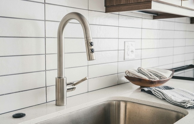Modera Germantown  kitchen boasts a sleek white subway tile backsplash and stainless steel hardware, adding a contemporary flair to your culinary haven