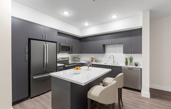 Model kitchen with dark cabinetry and bar