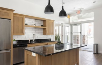 a kitchen with wooden cabinets and a large island with a black countertop