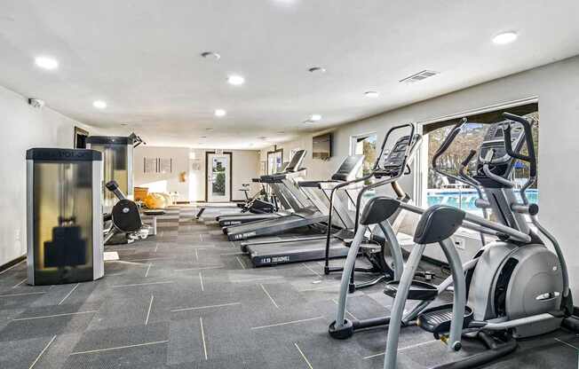 A gym with treadmills and elliptical machines.