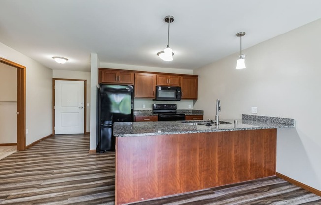 a kitchen with a granite counter top and a black refrigerator