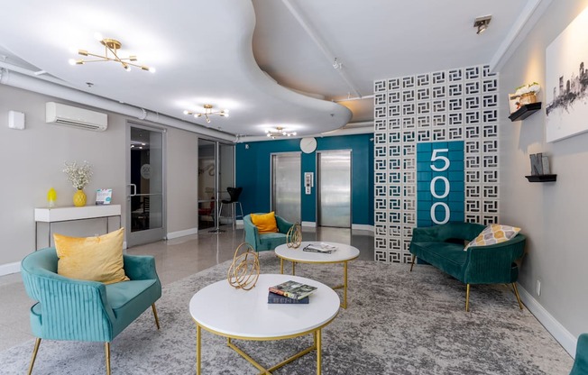 a living room with blue and yellow furniture and a lobby with a 50o sign