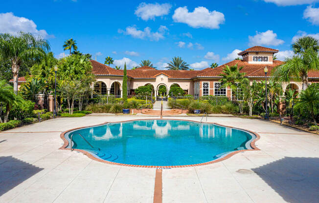 a large swimming pool in front of a mansion