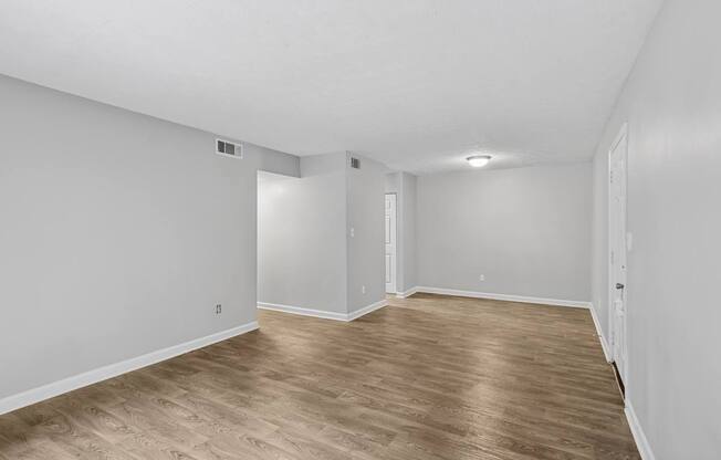A room with wooden flooring and white walls.