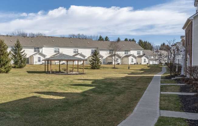 a park with a gazebo in front of a row of houses at Traditions at Slate Ridge, Reynoldsburg, OH