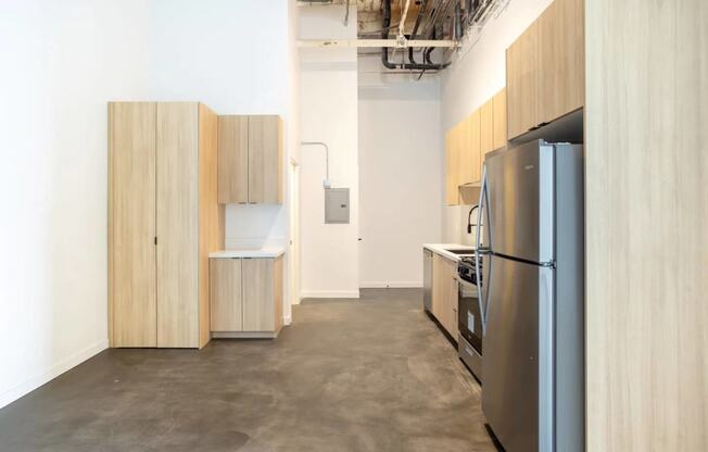 a kitchen with a refrigerator and cabinets in a room