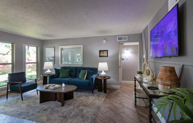 The leasing office with a blue couch and a television on the wall at The Summit at Midtown Apartments in Midtown, Dallas, TX.
