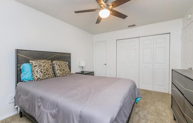 a bedroom with a bed and desk in a room