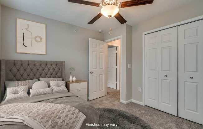 a bedroom with a bed and a ceiling fan